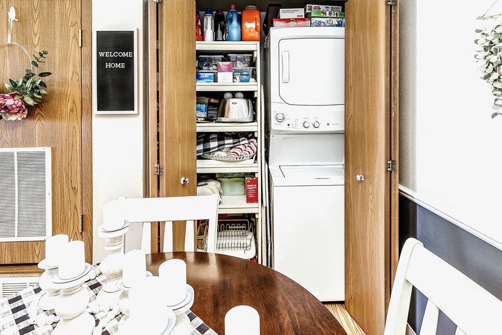 a kitchen with a table and a refrigerator and a washing machine