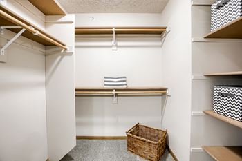 A small closet with a basket on the floor.
