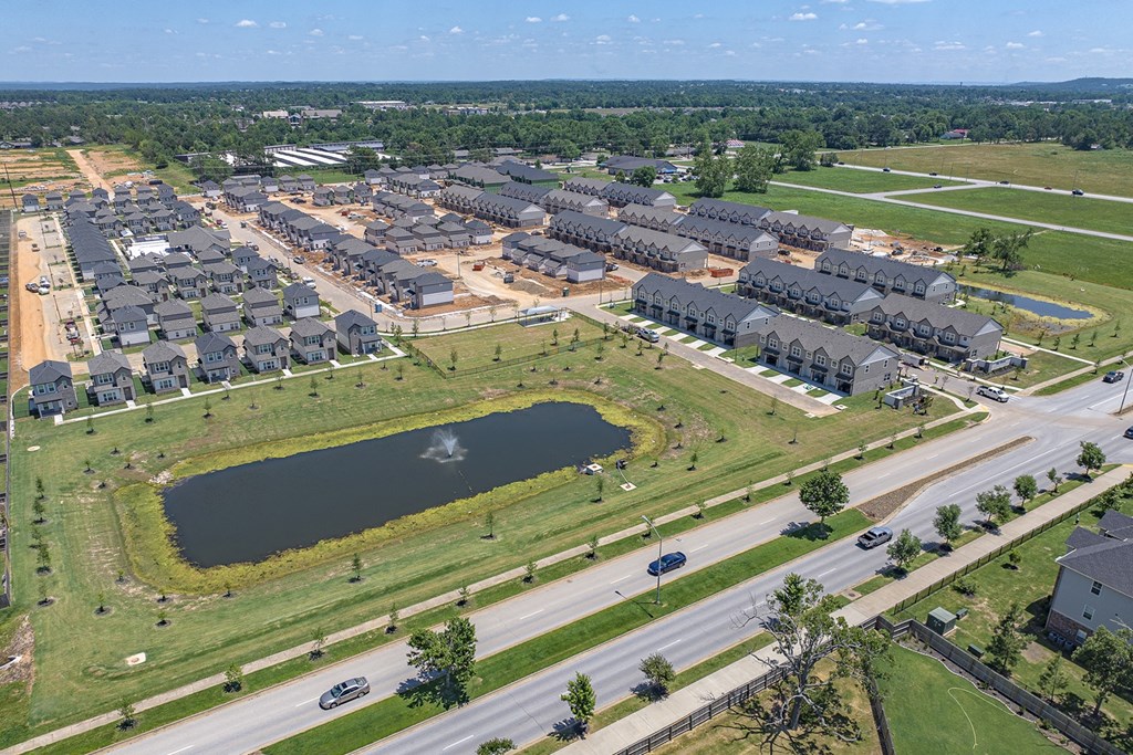 an aerial view of a city with a pond in the middle