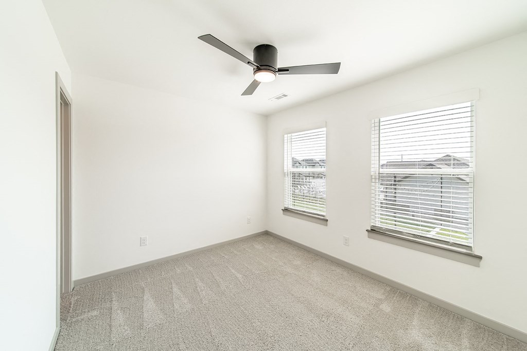 Bedroom with multiple windows at The Grove in Rogers, AR