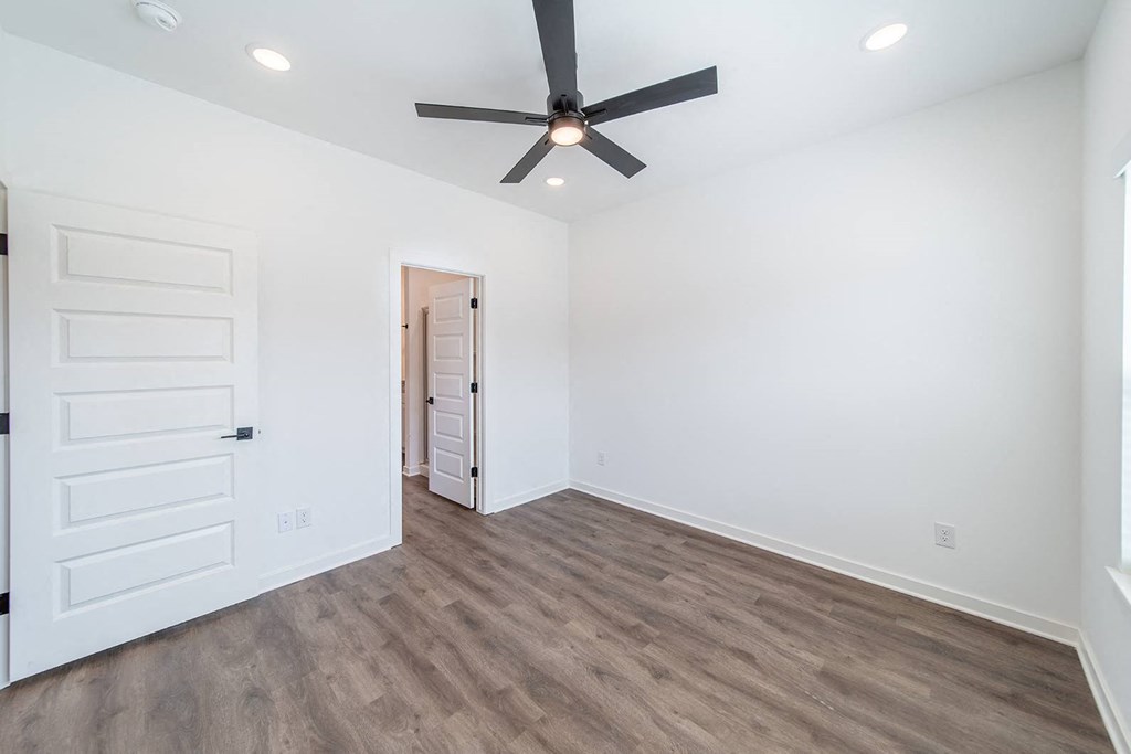 Bedroom with hard wood flooring at The Grove in Rogers, AR