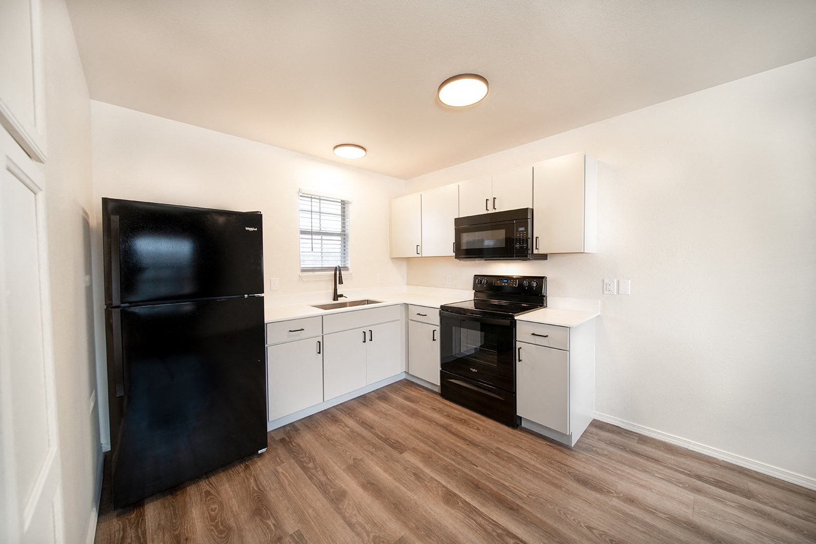 Newly remodeled one and two-bedroom floor plans with premium appliances, custom cabinetry, quartz countertops, premium LVT flooring, and in-unit washer and dryer at The Grove on Berry in Springdale, AR.