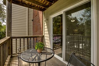 A small table with a plant on it is on a balcony.