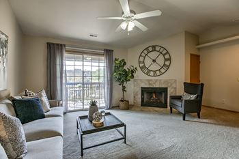 A living room with a fireplace and a ceiling fan.