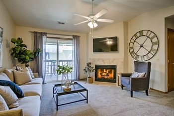 A living room with a fireplace, a couch, a chair, and a television.