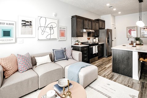 A modern living room with a beige couch and a coffee table.