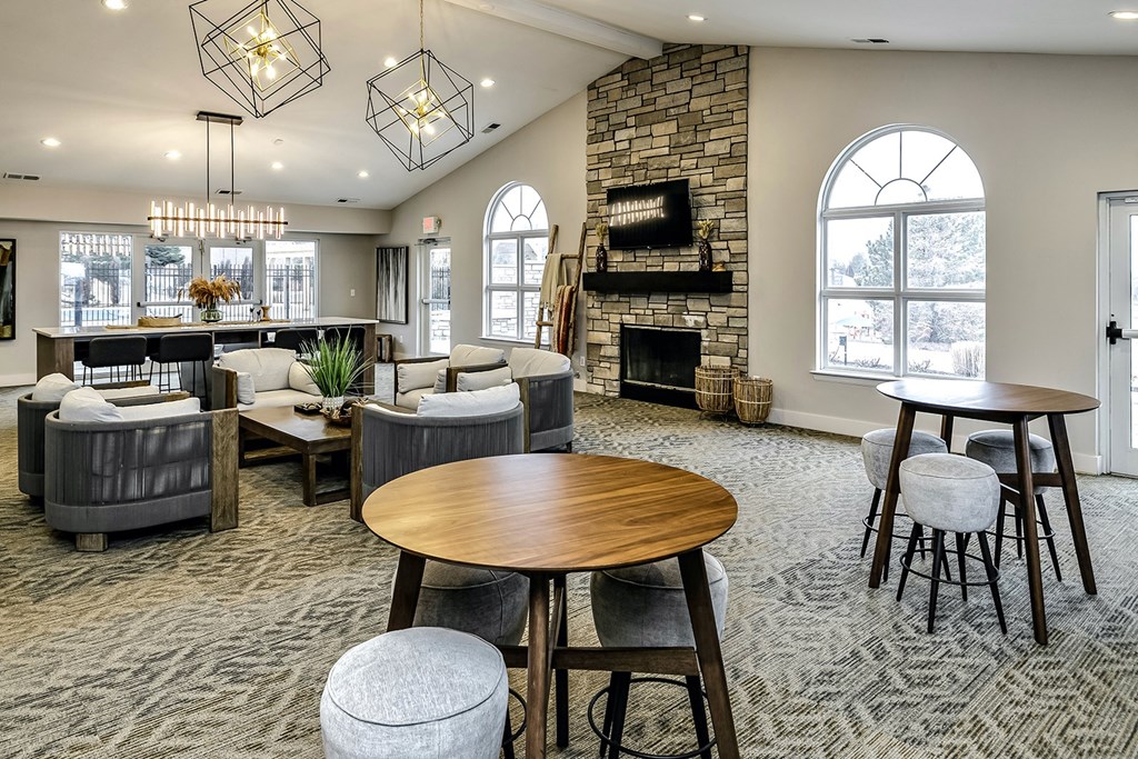 a resident clubhouse with couches tables and chairs and a fireplace