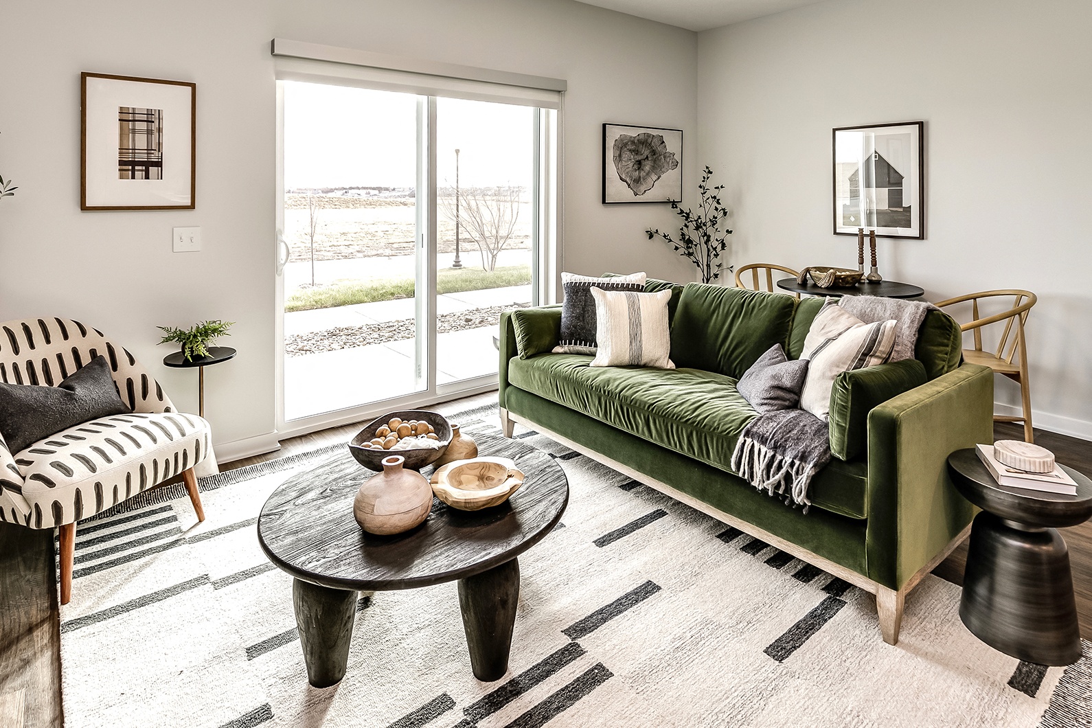 a living room with a green couch and a large window