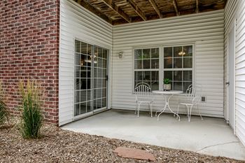 A patio with a table and chairs is attached to a house.