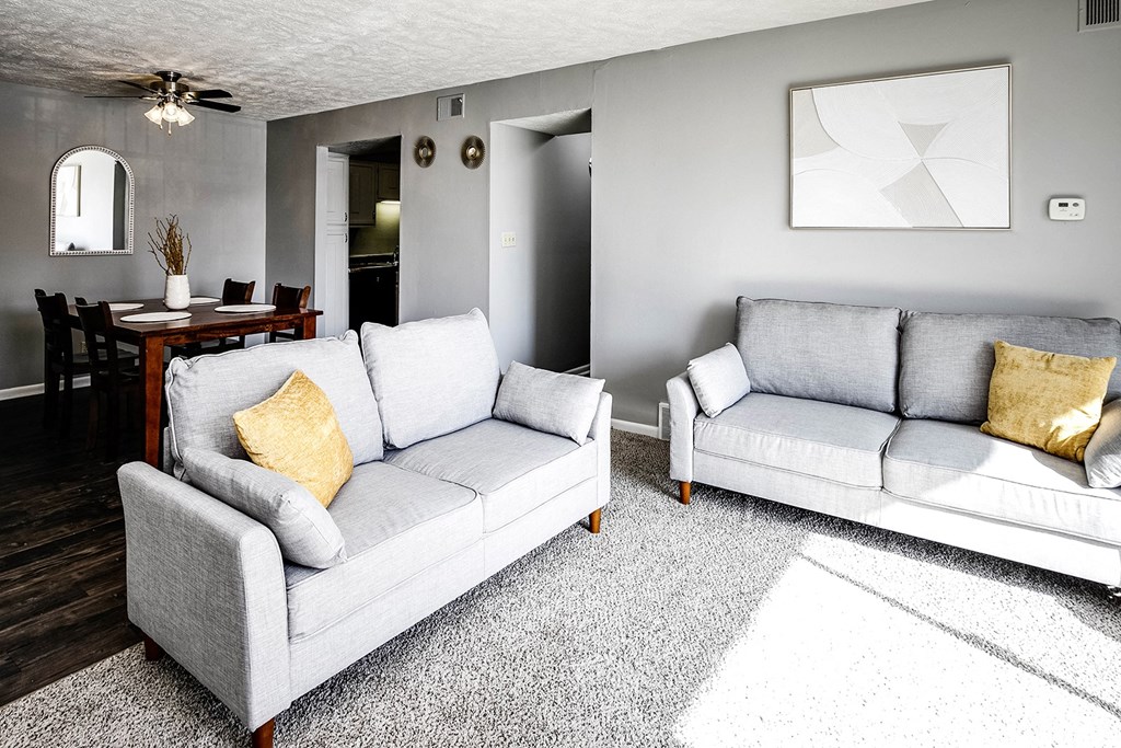 a living room with two couches and a dining room table