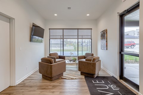 A living room with two chairs and a rug in front of a glass door.