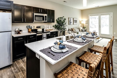 a kitchen and living room with a table and chairs