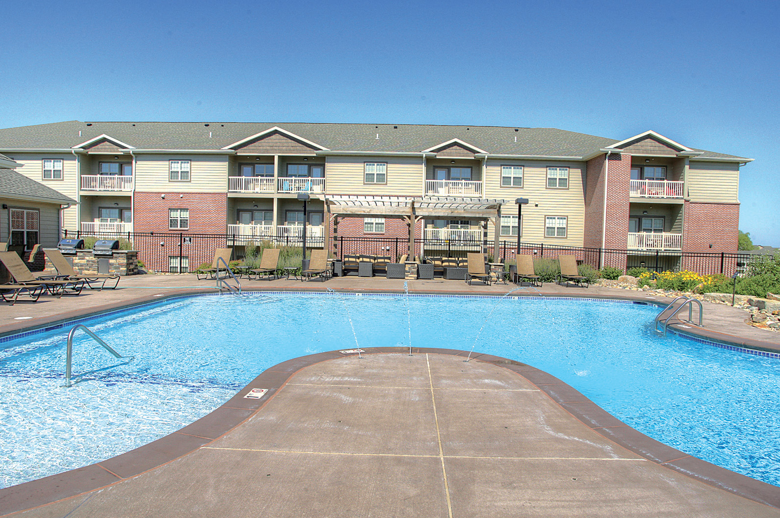 a swimming pool with an apartment building in the background