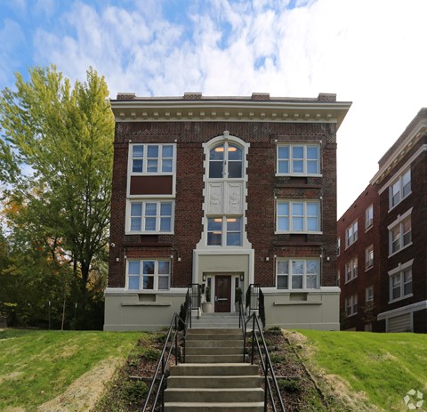 A red brick building with a white door and windows.