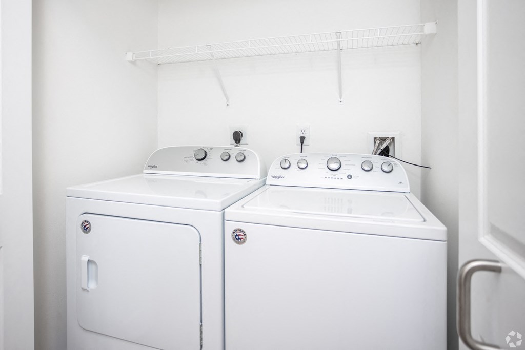 a white washer and dryer in a room with a white wall and a