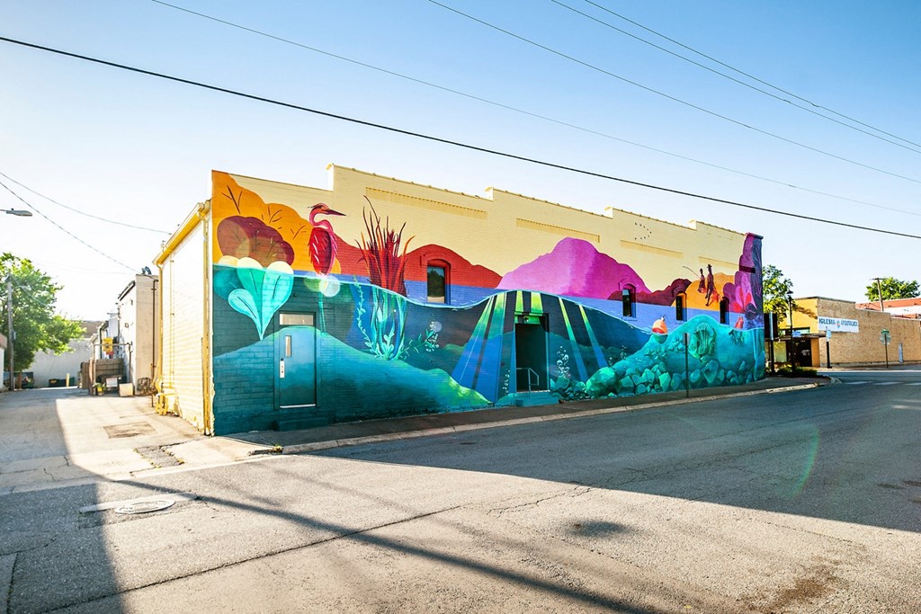 a mural on the side of a building on a street
