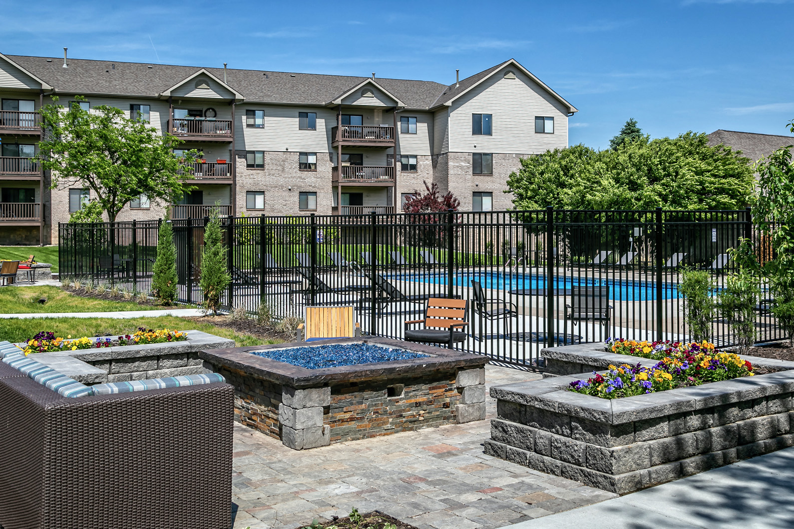 an apartment building with a swimming pool and fire pit