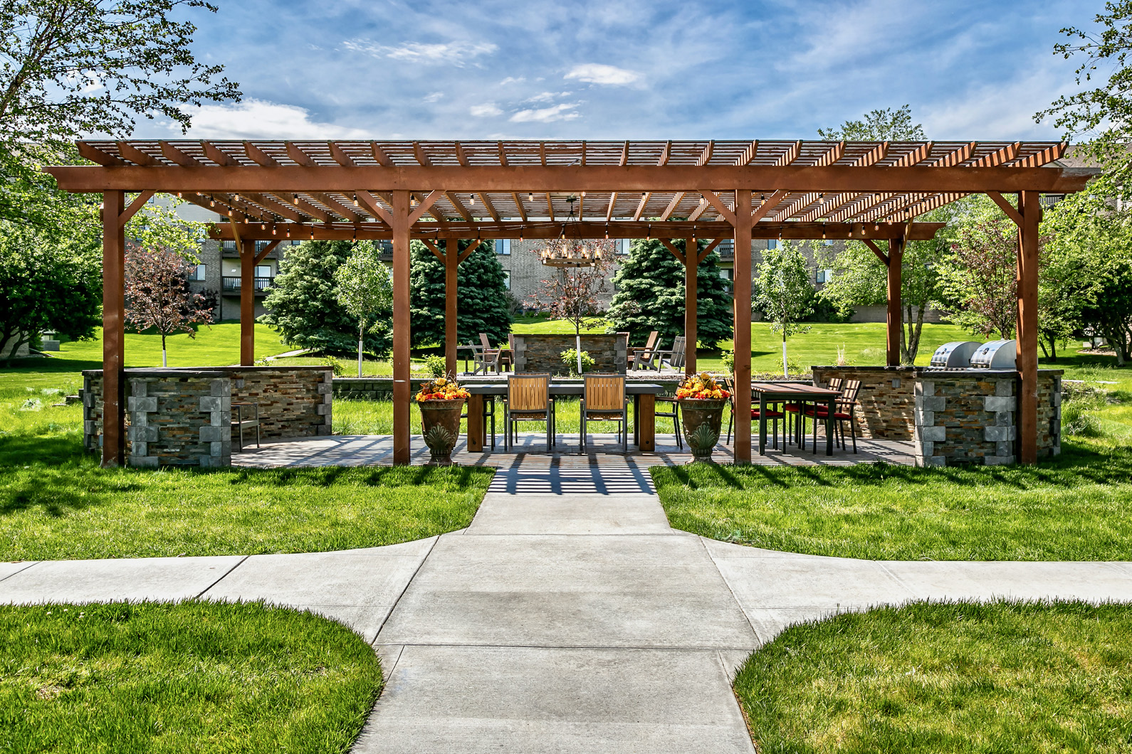 a pergola with a table and chairs in a yard