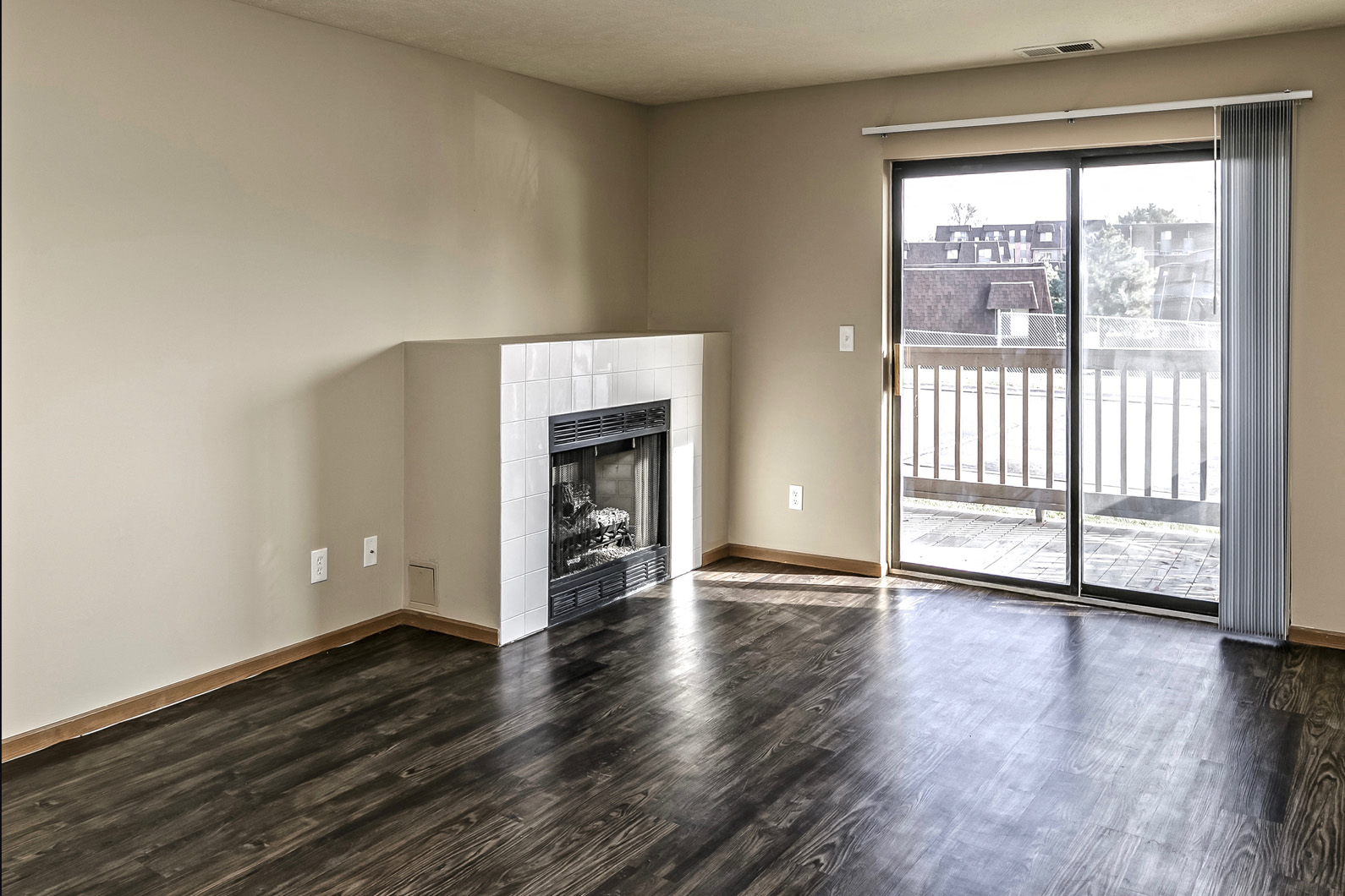 an empty living room with a fireplace and a balcony