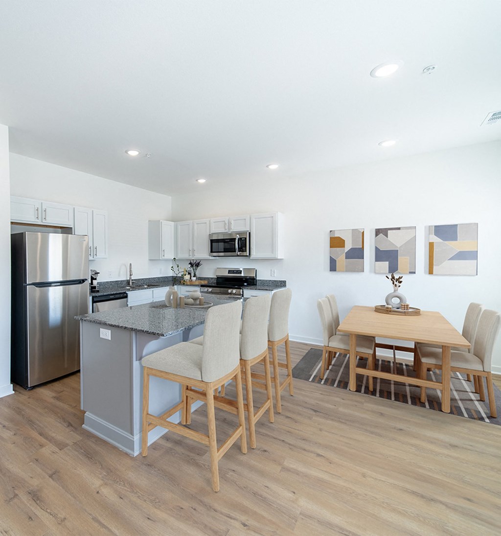 a kitchen and dining area with stainless steel appliances and a wooden table