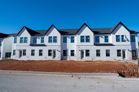 a large white building with a pile of dirt in front of it