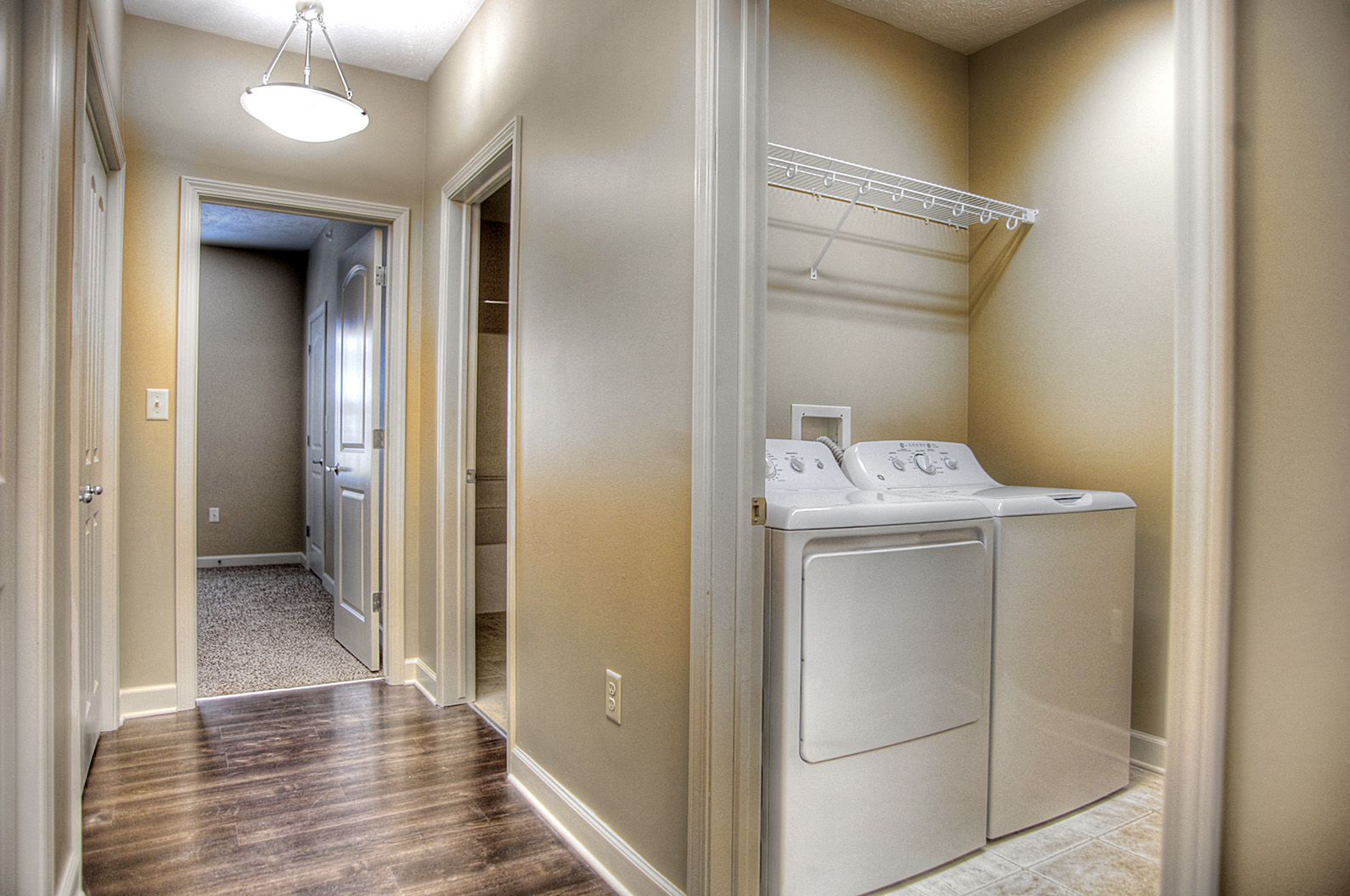a laundry room with a washer and dryer and a hallway with a door