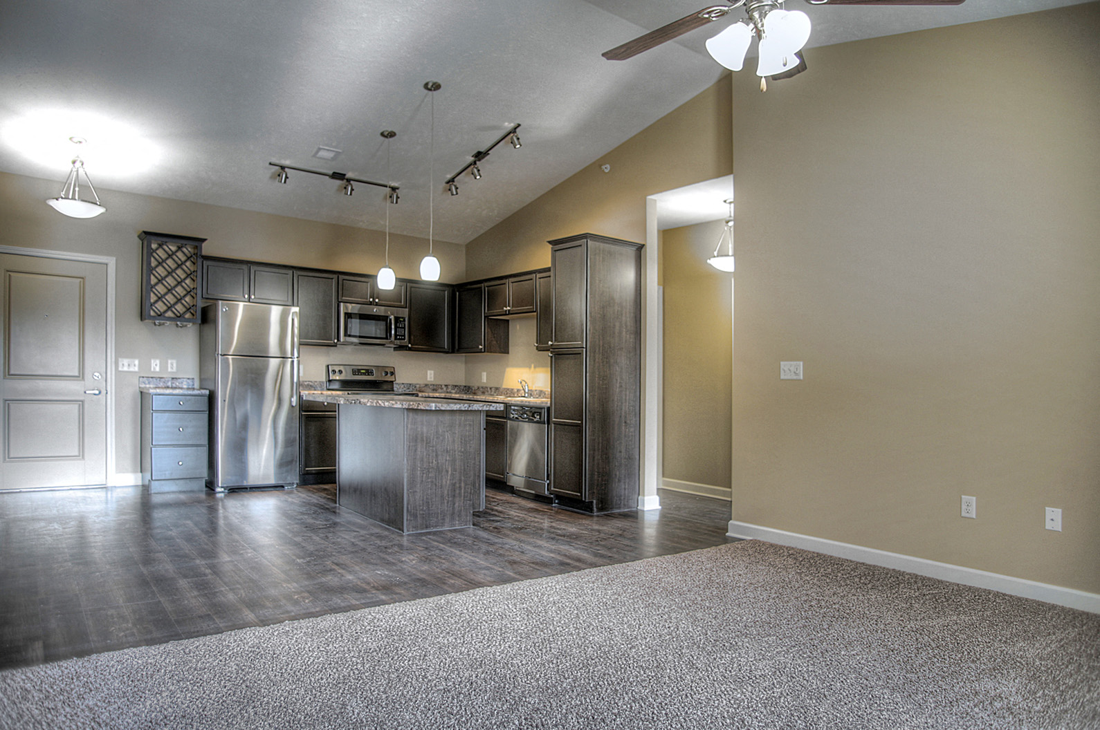 an empty kitchen with stainless steel appliances and a granite island