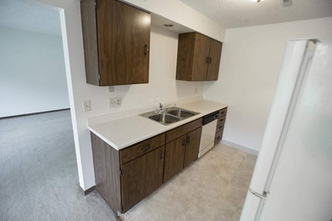 A kitchen with brown cabinets and a white countertop.