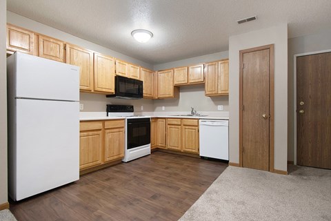 A kitchen with wooden cabinets and white appliances.