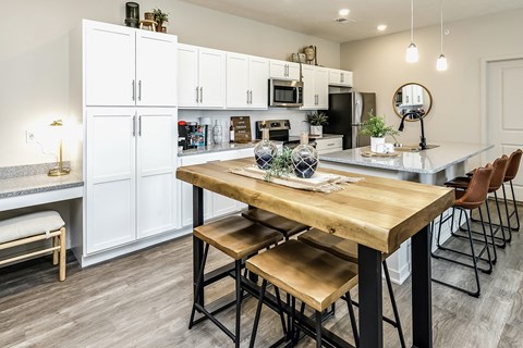 a kitchen with white cabinets and a table with stools