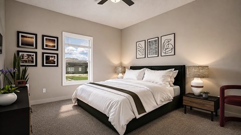 Bedroom with large window, bed, nightstands and ceiling fan.