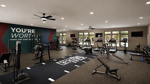 A gym with a variety of equipment and a motivational message on the wall.