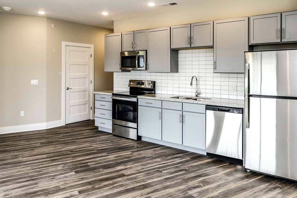 Large kitchens with white or black backsplashes at The Mill Apartments in Benson, NE