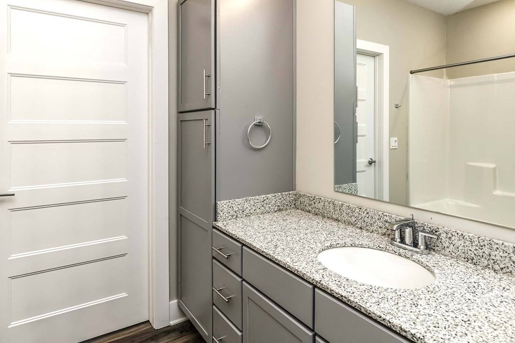 Large bathrooms with extra storage and granite countertops at The Mill Apartments in Benson, NE