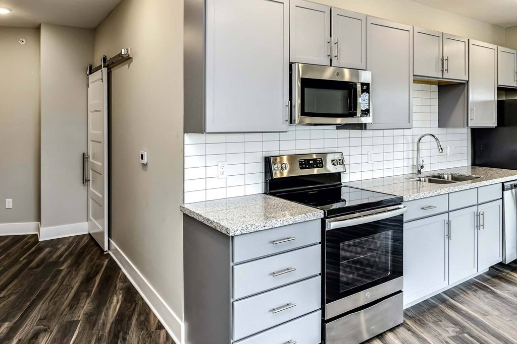 Large kitchens with white or black backsplashes at The Mill Apartments in Benson, NE