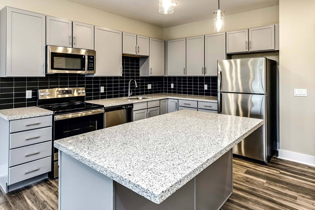 Large kitchens with white or black backsplashes at The Mill Apartments in Benson, NE