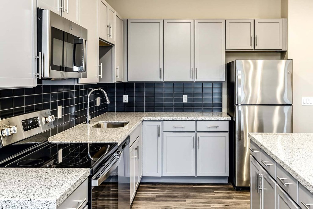 Large kitchens with white or black backsplashes at The Mill Apartments in Benson, NE