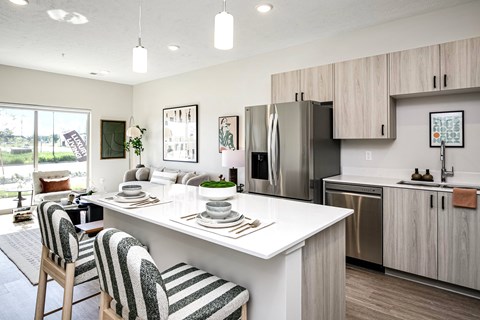 A modern kitchen with a striped chair at the table.