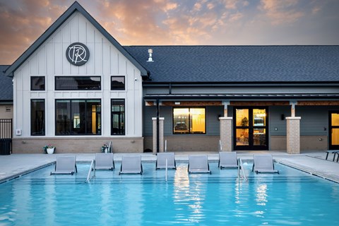 A pool in front of a building with a logo on it.