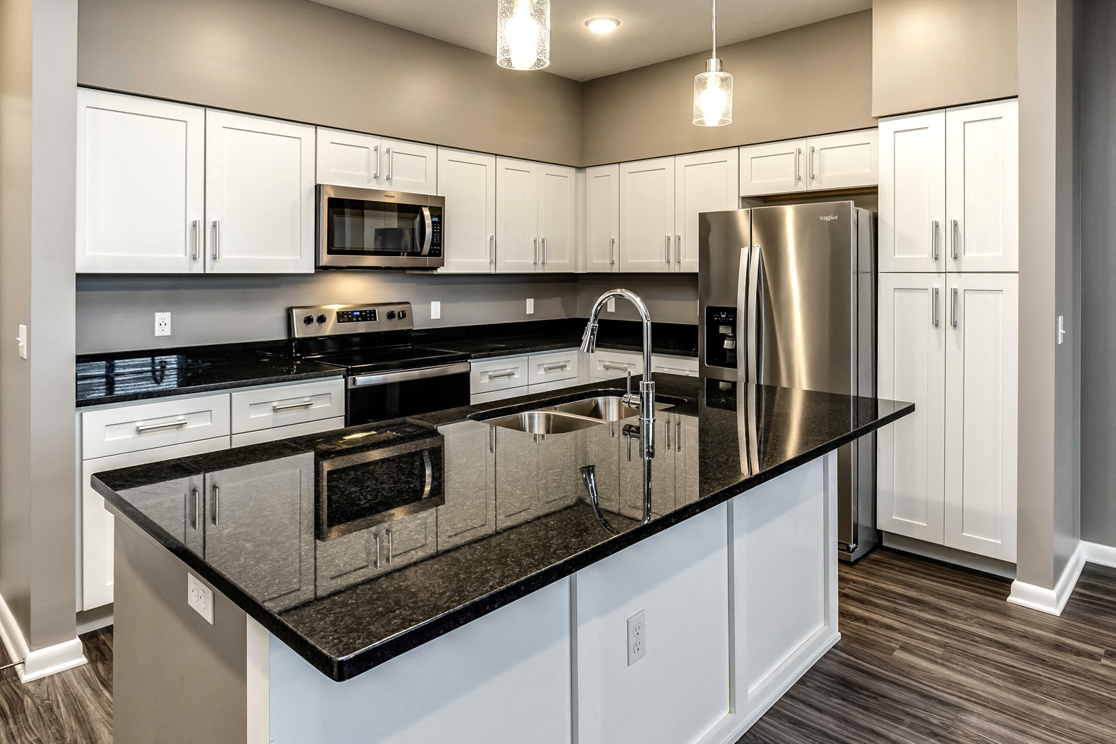 White cabinet kitchen with large island at The Apartments at Lux 96 in Papillion, NE