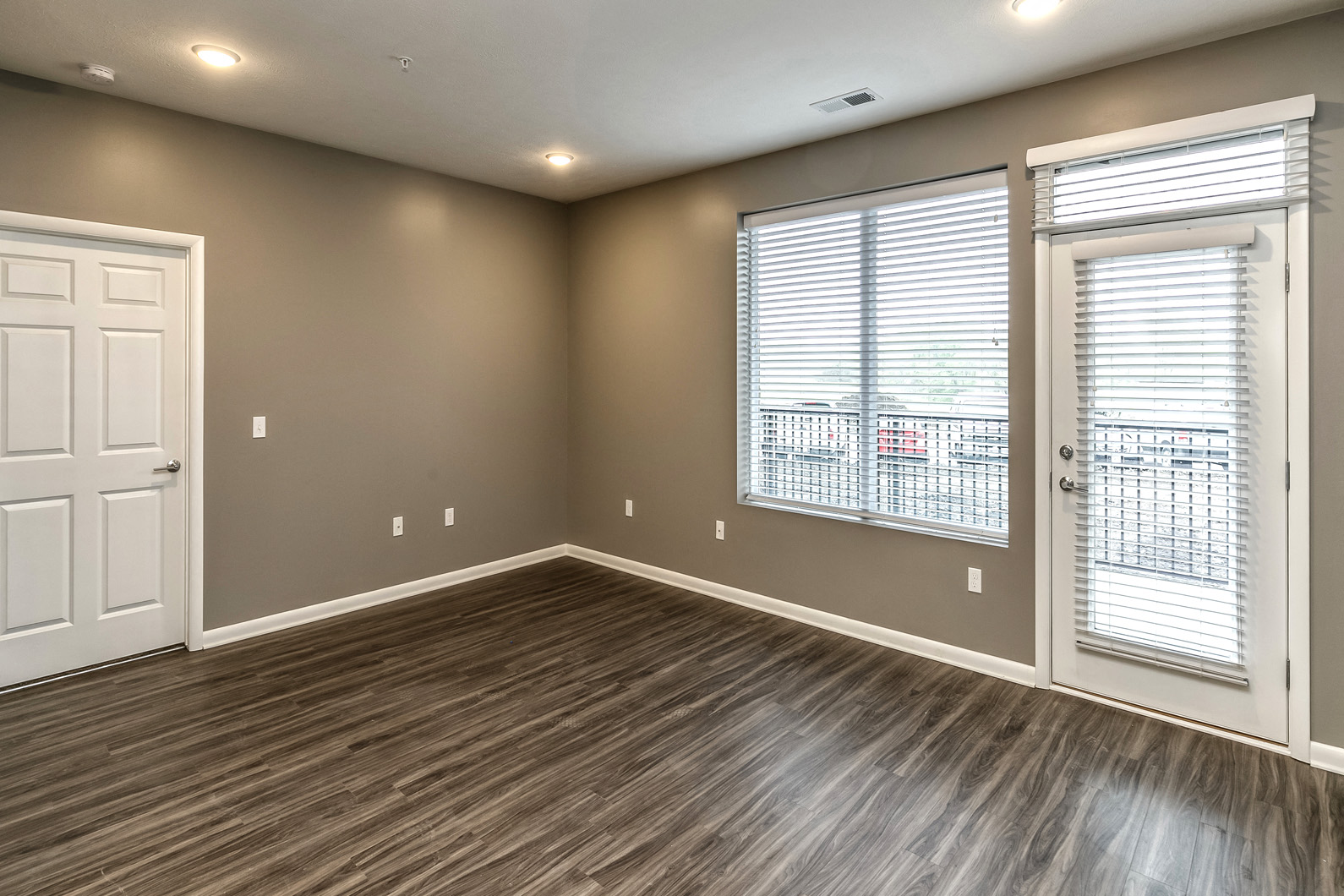 Living area with wood plank flooring at The Apartments at Lux 96 in Papillion, NE