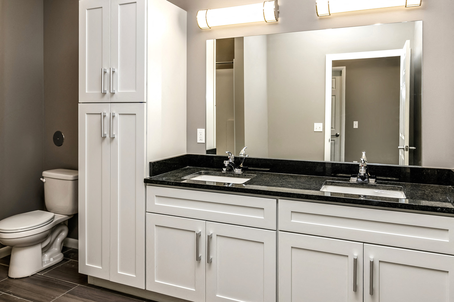 Double sink vanity with white cabinets at The Apartments at Lux 96 in Papillion, NE