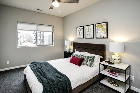 VUE 19 (Model 2Bd) - Bedroom with a bed, nightstand, and a window.