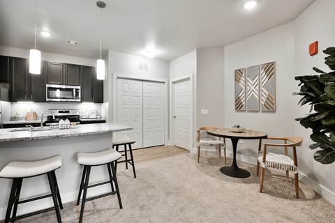 A kitchen with a bar area and a dining table.