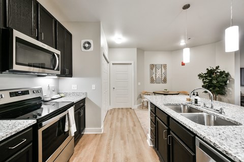 A kitchen with black cabinets and granite countertops.