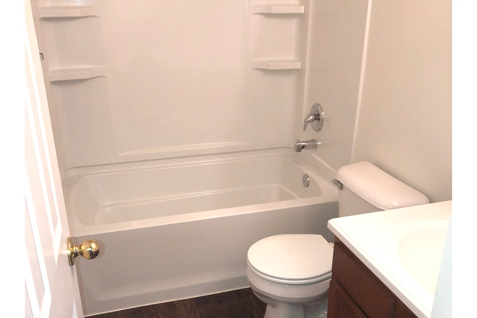 a white bathroom with a toilet and a bath tub