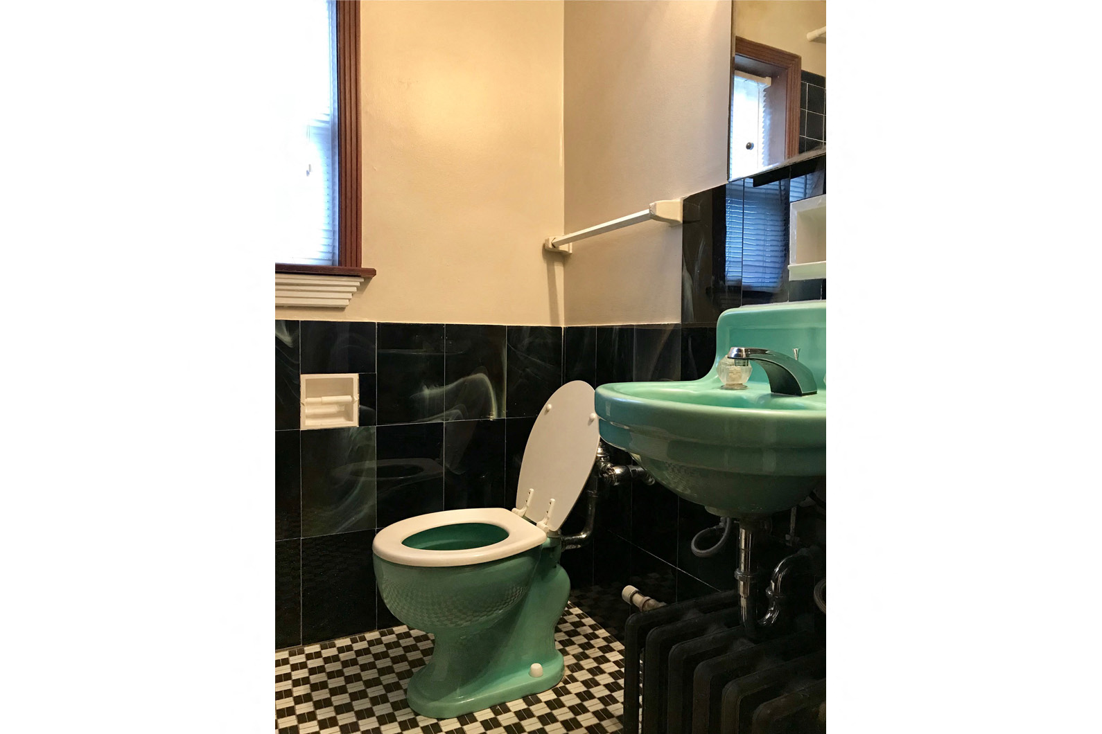 a green toilet and a sink in a bathroom