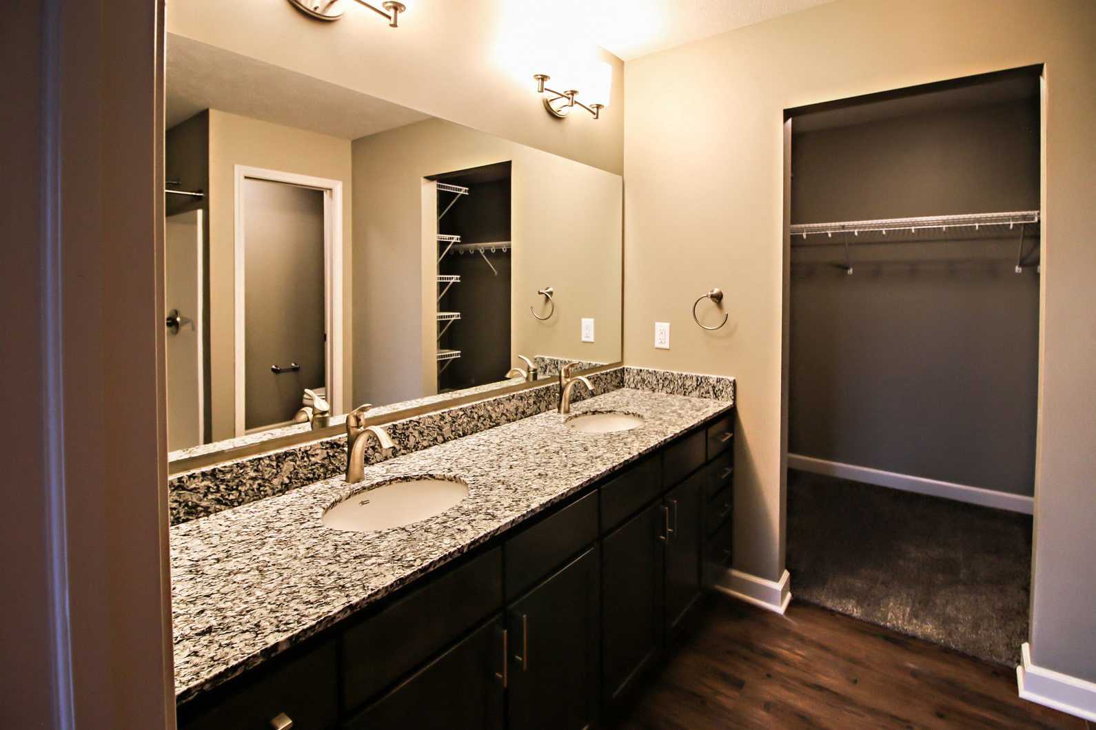 a bathroom with granite counter tops and two sinks and mirrors
