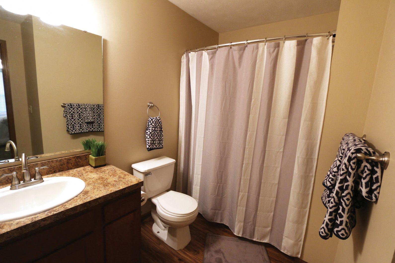 a bathroom with a white shower curtain and a toilet and sink