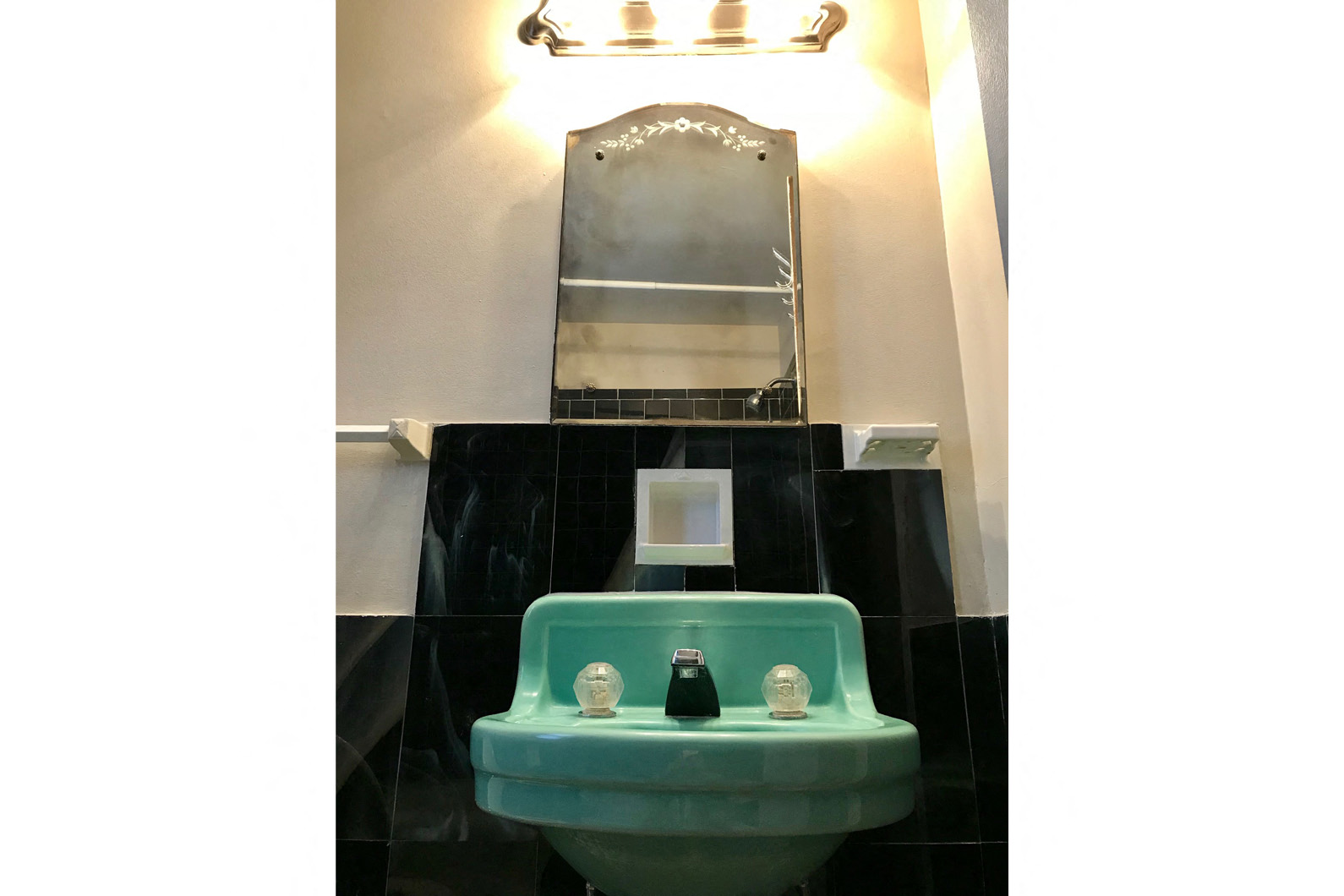 a bathroom with a green sink and a mirror
